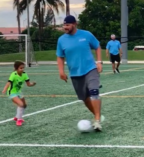 Ryan playing soccer in a Dads vs. Kids match